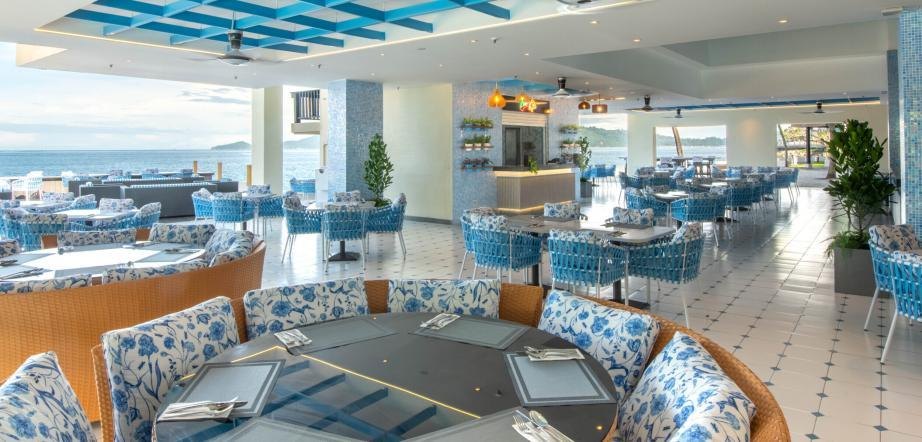 The Al Fresco dining room, patterned armchairs facing the open sea view