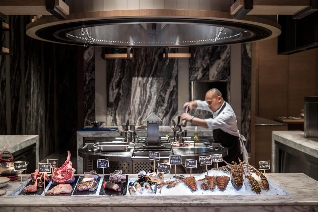 A chef preparing seafood at the Big Fish display counter