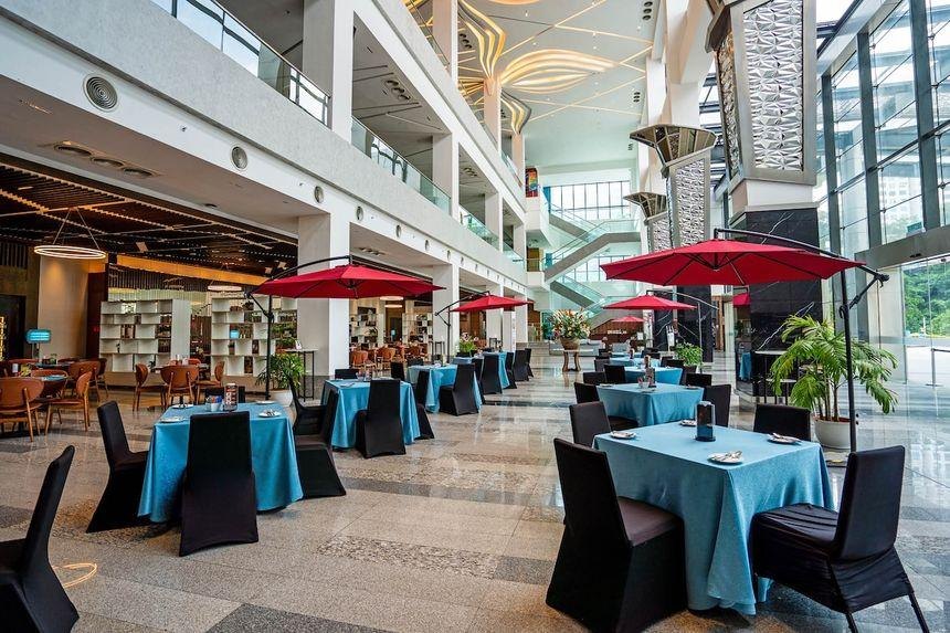 The convention centre atrium set for an event with tables and red parasols